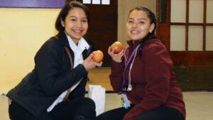 Cristo Rey Kansas City students show off the apples they received as part of the Apple a Day program.