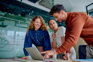 three business people looking at a laptop